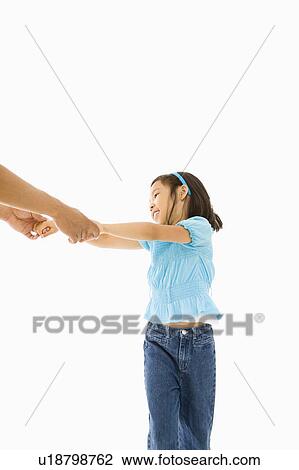 Stock Image - Asian girl playing and holding hands with father.. Fotosearch