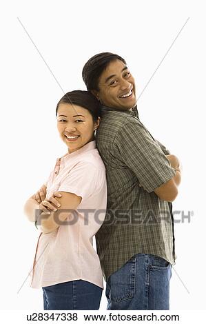 Asian man and woman standing back to back and smiling. View Large Photo Image Stock Photo - Asian man and woman standing back to back and smiling.. Fotosearch
