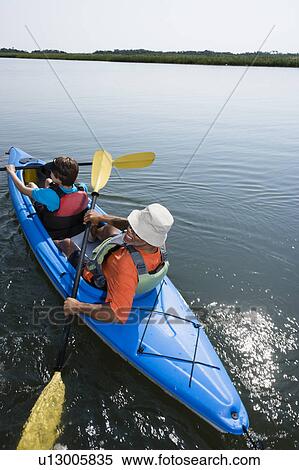 Back view of African American middle-aged couple paddling kayak. View Large Photo Image Stock Photography - Back view of African American middle-aged couple paddling kayak.. Fotosearch