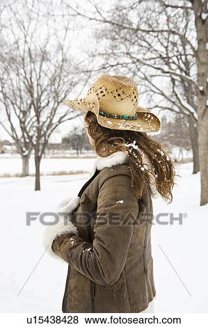 Back view of brunette woman with long hair wearing straw cowboy hat outdoors in the snow. View Large Photo Image Stock Photo - Back view of brunette woman with long hair wearing straw cowboy hat outdoors in the snow.. Fotosearch