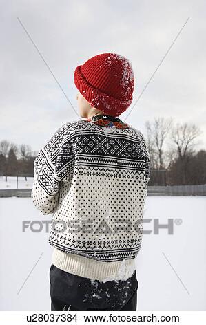 Picture - Back view of Caucasian boy wearing sweater and red winter cap.. Fotosearch