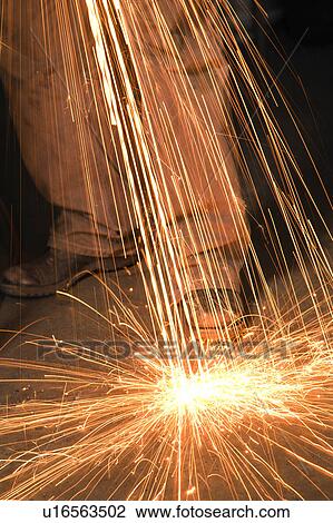 Caucasian male metalsmith shaping metal and creating sparks. View Large Photo Image Stock Image - Caucasian male metalsmith shaping metal and creating sparks.. Fotosearch