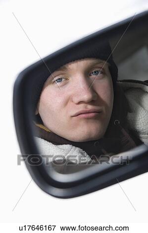 Caucasian male teenager looking at himself in side view mirror of car. View Large Photo Image Stock Photo - Caucasian male teenager looking at himself in side view mirror of car.. Fotosearch