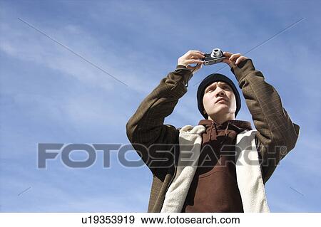 Caucasian male teenager taking a picture with a digital camera. View Large Photo Image Stock Photo - Caucasian male teenager taking a picture with a digital camera.. Fotosearch