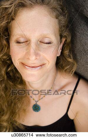 Picture - Caucasian mid-adult woman smiling with eyes closed.. Fotosearch