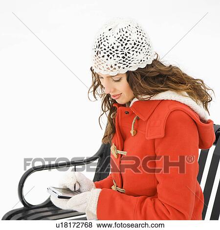 Caucasian young adult female in winter clothing sitting using PDA. View Large Photo Image Stock Photo - Caucasian young adult female in winter clothing sitting using PDA.. Fotosearch