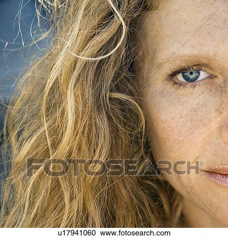 Stock Image - Close up of Caucasian mid-adult woman with wavy hair looking at viewer.. Fotosearch