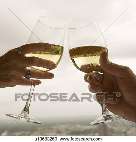 Close up of mature couple's hands toasting white wine. View Large Photo Image Stock Image - Close up of mature couple's hands toasting white wine.. Fotosearch