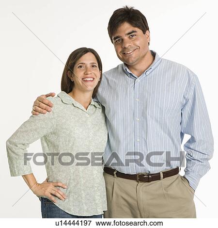 Stock Photo - Couple standing smiling against white background.. Fotosearch