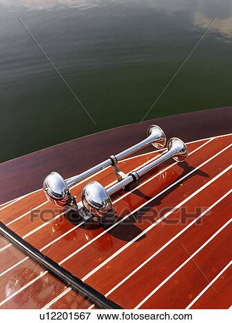 Detail of dual chrome trumpet horn on wooden boat floating in water. View Large Photo Image Stock Photo - Detail of dual chrome trumpet horn on wooden boat floating in water.. Fotosearch