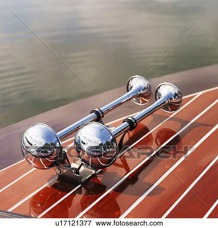 Detail of dual chrome trumpet horns on wooden boat floating in water. View Large Photo Image Stock Photo - Detail of dual chrome trumpet horns on wooden boat floating in water.. Fotosearch