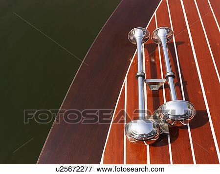 Detail of dual chrome trumpet horns on wooden boat floating in water. View Large Photo Image Stock Photo - Detail of dual chrome trumpet horns on wooden boat floating in water.. Fotosearch