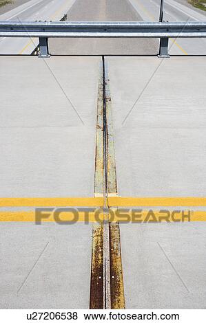 Stock Photo - Detail of solid double yellow line in road on overpass with highway below.. Fotosearch