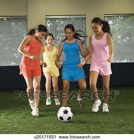 Four multiethnic girls playing soccer and laughing in indoor gym. View Large Photo Image Stock Image - Four multiethnic girls playing soccer and laughing in indoor gym.. Fotosearch