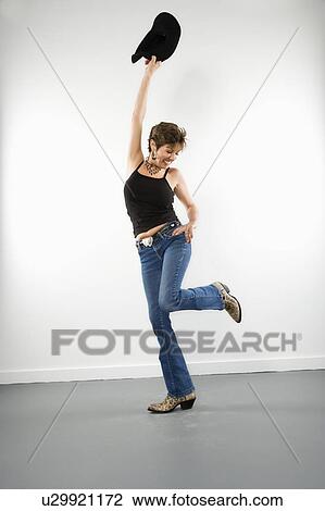 Full length portrait of pretty Caucasian woman holding up cowboy hat in playful pose. View Large Photo Image Stock Image - Full length portrait of pretty Caucasian woman holding up cowboy hat in playful pose.. Fotosearch