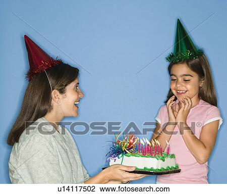 Girl wearing party hat with mother holding birthday cake. View Large Photo Image Stock Image - Girl wearing party hat with mother holding birthday cake.. Fotosearch