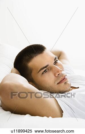 Handsome Caucasian mid adult man lying with hands behind head. View Large Photo Image Stock Photography - Handsome Caucasian mid adult man lying with hands behind head.. Fotosearch