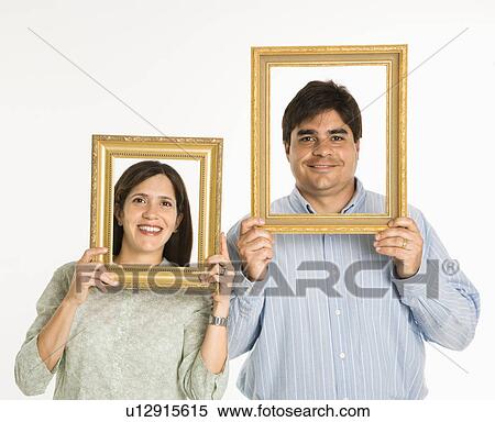 Stock Photography - Man and woman looking through empty frames.. Fotosearch