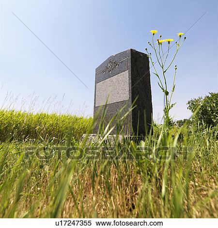 Stock Photography - Marble headstone in rural field under blue sky.. Fotosearch