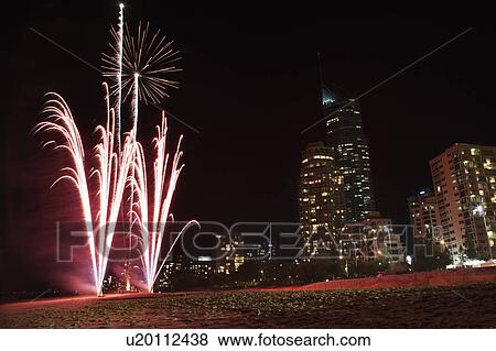 Stock Photo - Night firework display exploding with Surfers Paradise city skyline in Australia.. Fotosearch