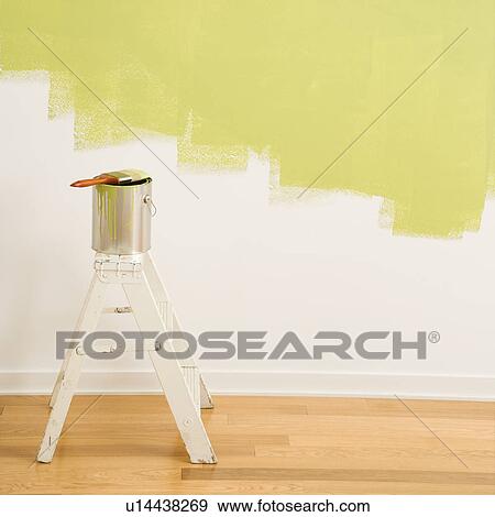 Stock Photo - Paintbrush on can on top of step ladder with painted wall.. Fotosearch