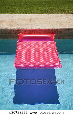 Stock Image - Pink float in empty swimming pool.. Fotosearch