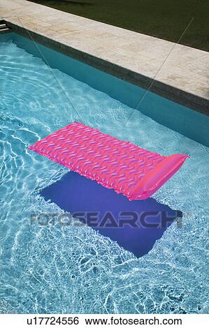 Stock Photograph - Pink lounge float in empty swimming pool.. Fotosearch