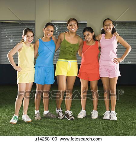 Portrait of four girls and one woman standing together smiling in indoor gym. View Large Photo Image Stock Image - Portrait of four girls and one woman standing together smiling in indoor gym.. Fotosearch