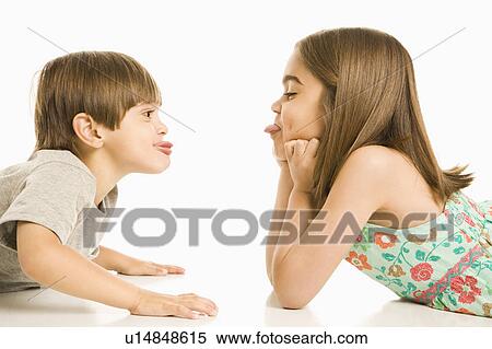 Portrait of girl and boy lying looking at eachother sticking out tongues. View Large Photo Image Stock Photography - Portrait of girl and boy lying looking at eachother sticking out tongues.. Fotosearch