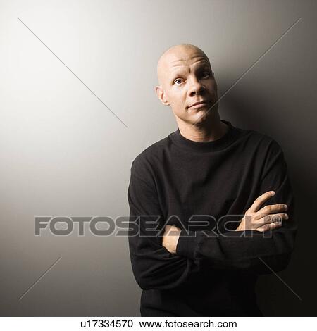 Stock Image - Portrait of mid-adult Caucasian male with arms crossed.. Fotosearch