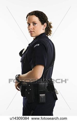 Portrait of mid adult Caucasian policewoman standing with hand on gun holster looking over shoulder at viewer. View Large Photo Image Picture - Portrait of mid adult Caucasian policewoman standing with hand on gun holster looking over shoulder at viewer.. Fotosearch