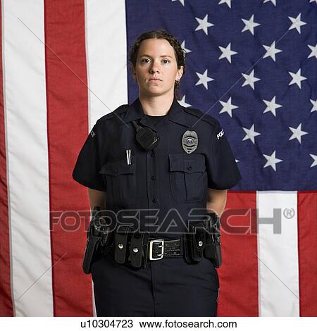Portrait of mid adult Caucasian policewoman standing with arms behind back and American flag as backdrop. View Large Photo Image Stock Image - Portrait of mid adult Caucasian policewoman standing with arms behind back and American flag as backdrop.. Fotosearch