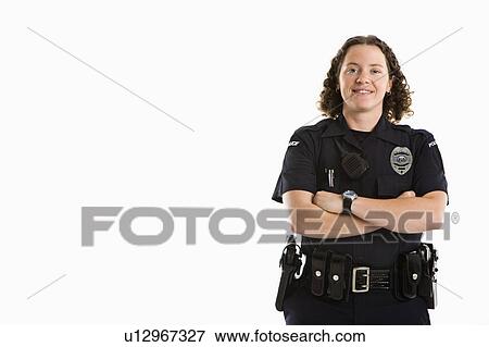 Stock Photo - Portrait of mid adult Caucasian policewoman standing with arms crossed looking at viewer smiling.. Fotosearch