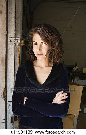 Portrait of pretty Caucasian woman standing with arms crossed making eye contact. View Large Photo Image Stock Photo - Portrait of pretty Caucasian woman standing with arms crossed making eye contact.. Fotosearch