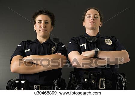 Portrait of two mid adult Caucasian policewomen standing with their arms crossed looking at viewer with serious expressions. View Large Photo Image Stock Photo - Portrait of two mid adult Caucasian policewomen standing with their arms crossed looking at viewer with serious expressions.. Fotosearch