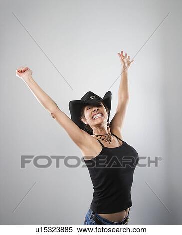 Stock Photography - Portrait of woman smiling and holding arms up in air.. Fotosearch