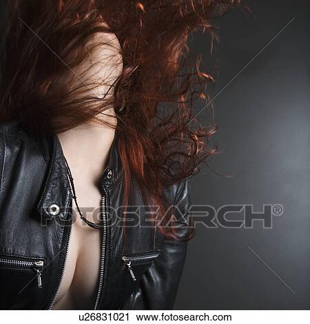 Stock Image - Pretty redhead young woman flipping head back with long hair flying out.. Fotosearch