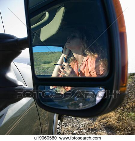 Reflection in vehicle side mirror of Caucasian woman applying mascara. View Large Photo Image Stock Image - Reflection in vehicle side mirror of Caucasian woman applying mascara.. Fotosearch