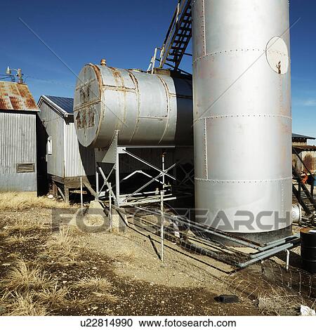 Stock Image - Rural landscape with metal tanks.. Fotosearch