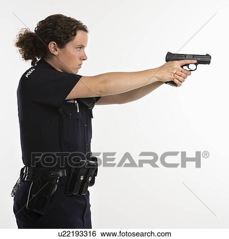 Stock Photograph - Side view of mid adult Caucasian policewoman standing and aiming handgun with arms outstretched.. Fotosearch