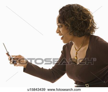 Stock Photo - Side view of woman looking at cellphone with happy expression.. Fotosearch