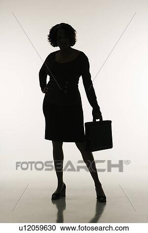 Stock Image - Silhouette of businesswoman holding briefcase.. Fotosearch
