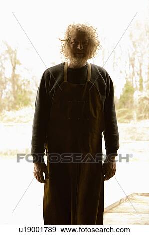 Stock Photo - Silhouetted portrait of Caucasian male metalsmith in his workshop.. Fotosearch
