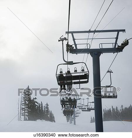 Skiers riding the chairlift in foggy winter weather. View Large Photo Image Stock Image - Skiers riding the chairlift in foggy winter weather.. Fotosearch