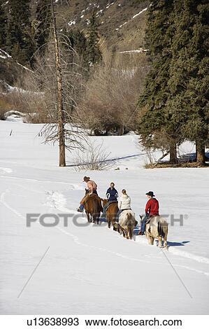 Small group of people horseback riding in snow covered landscape in Colorado, USA. View Large Photo Image Stock Image - Small group of people horseback riding in snow covered landscape in Colorado, USA.. Fotosearch
