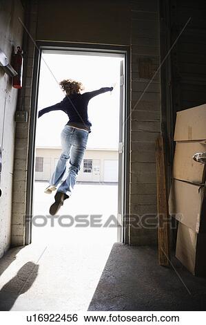 Woman running and jumping through open door from building to sunny outside. View Large Photo Image Stock Photograph - Woman running and jumping through open door from building to sunny outside.. Fotosearch