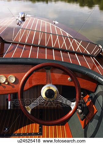 Wooden boat with steering wheel and dashboard floating in gentle water. View Large Photo Image Stock Photo - Wooden boat with steering wheel and dashboard floating in gentle water.. Fotosearch