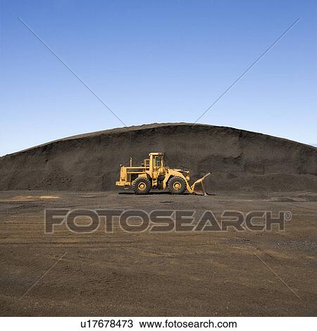 Yellow bulldozer parked beside large mound of dirt and rock. View Large Photo Image Stock Image - Yellow bulldozer parked beside large mound of dirt and rock.. Fotosearch