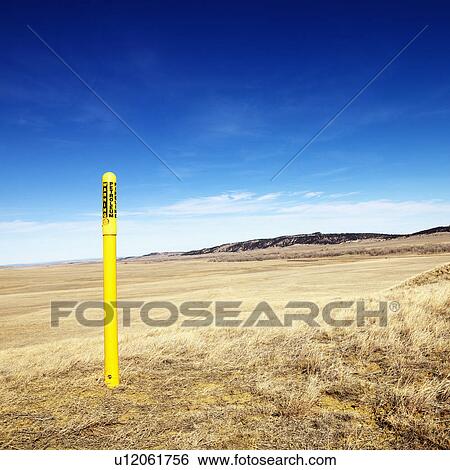 Stock Photograph - Yellow petroleum warning pole in scenic landscape.. Fotosearch