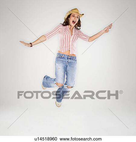 Young adult Caucasian woman wearing cowboy hat leaping into air with excited expression. View Large Photo Image Stock Image - Young adult Caucasian woman wearing cowboy hat leaping into air with excited expression.. Fotosearch